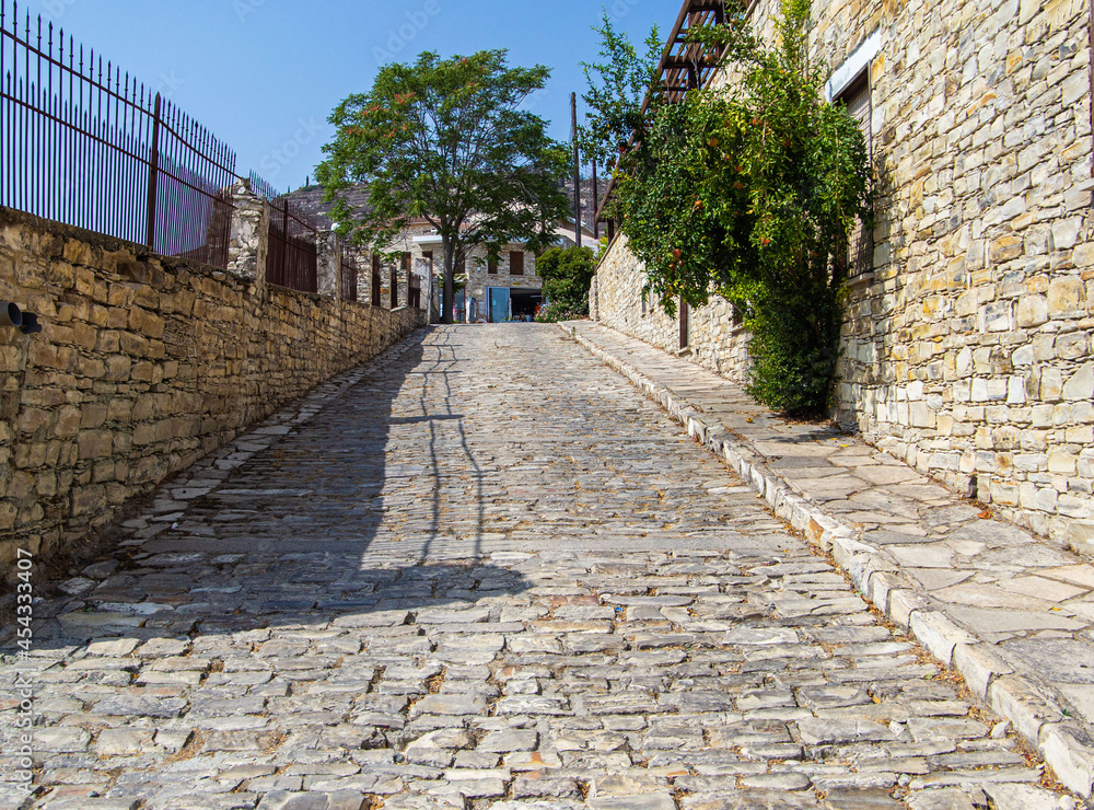 Obraz premium a beautiful street of the old city, a wall paved with light stone, a road, a sidewalk, everything for people's life