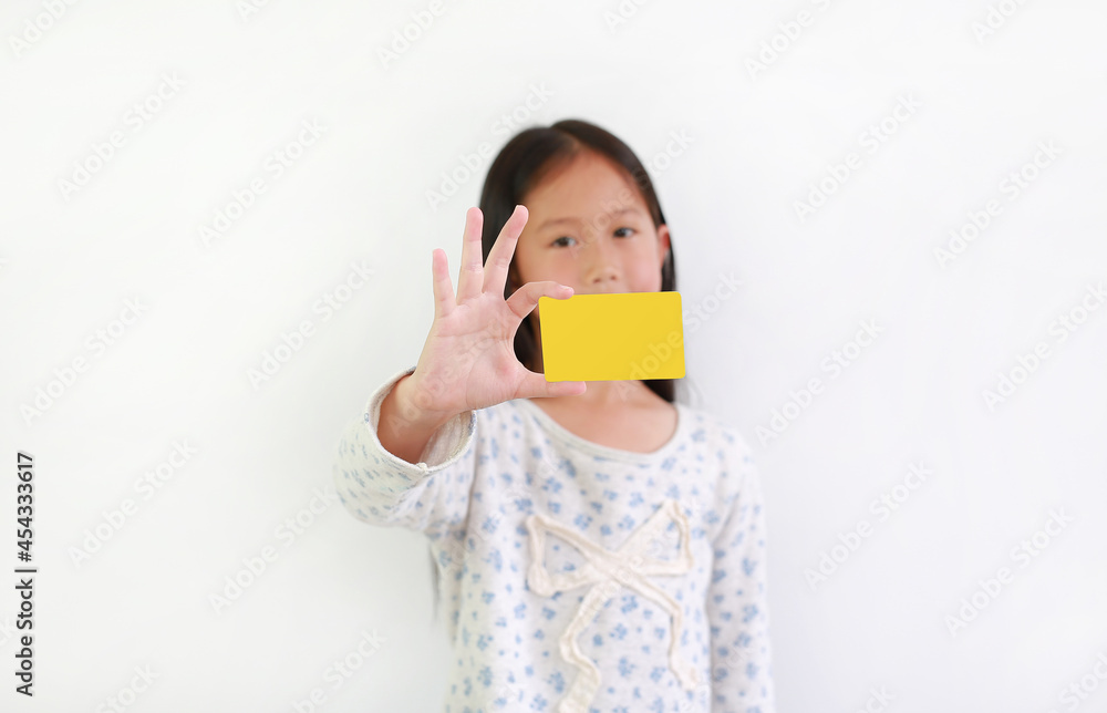 Caucasian little girl kid showing blank yellow card over white background. Focus at card in his hand Caucasian little girl kid showing blank yellow card over white background. Focus at card in his hand