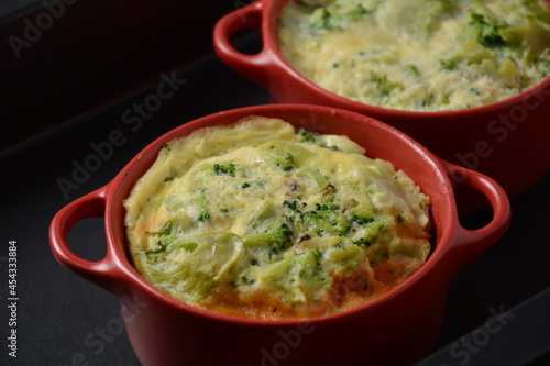 Healthy snack Broccoli  with eggs cheddar cheese and thyme close-up in mini casserole .