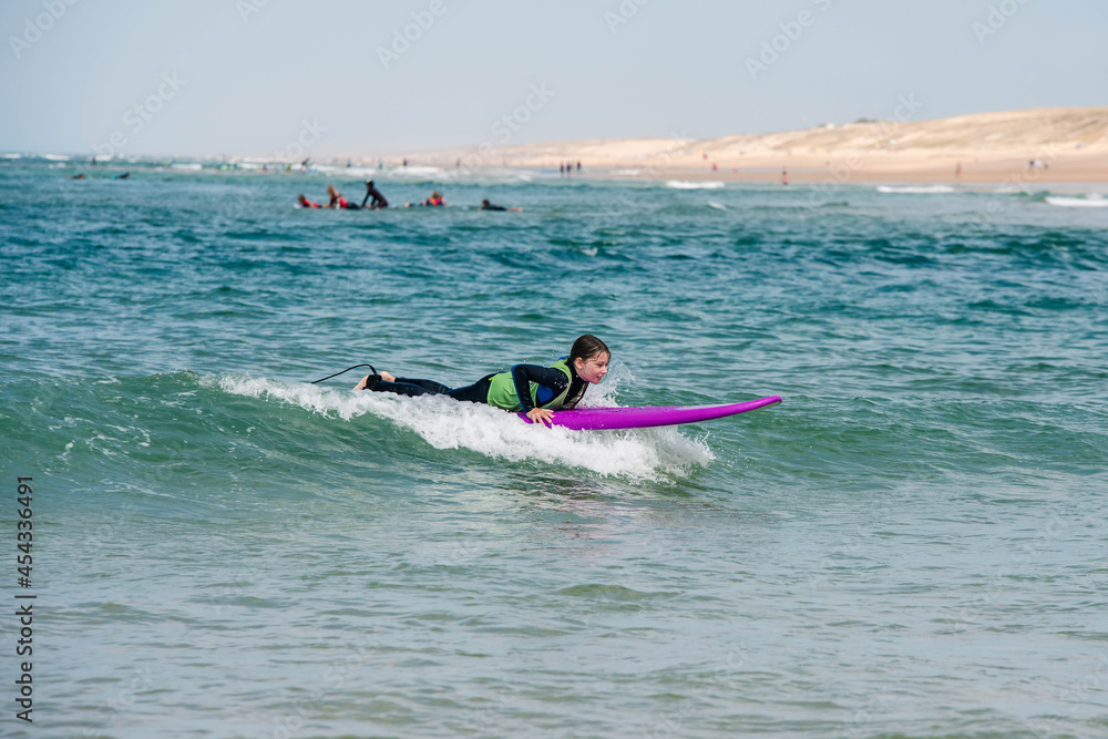 Naklejka premium cute young girl learning to surf