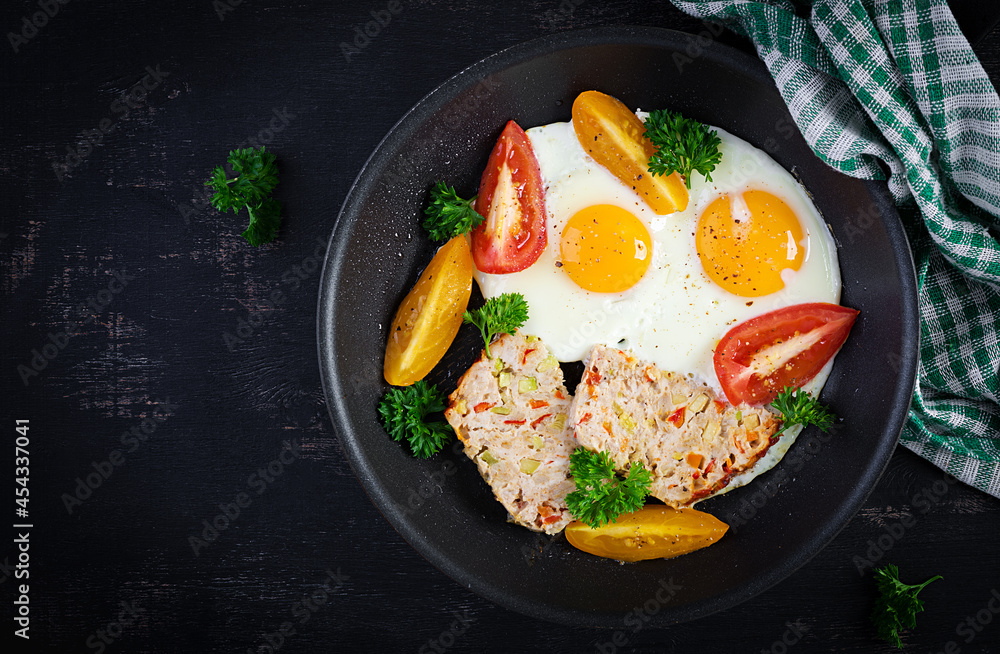 Plate with a keto diet food. Fried egg, meatloaf, and tomatoes. Keto, paleo breakfast. Top view, flat lay Plate with a keto diet food. Fried egg, meatloaf, and tomatoes. Keto, paleo breakfast. Top view, flat lay