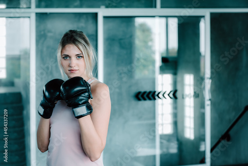 Female Boxer is Training Punch Boxing in Fitness Gym, Portrait of Sport Boxer Woman in Sportswear Exercised Practicing Boxing in Gym Club. Exercising Lifestyles and Fitness Sport Workout Training © Maha Heang 245789
