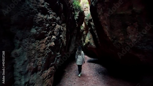 Friends inside cave against landscape. Romantic coupl Scenic rear view of a man and a woman walking in  outstanding caves against beautiful landscape in Cuevas de Zaen, Spain. Europe destinations.  photo