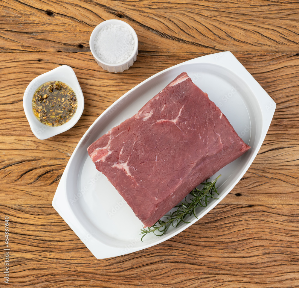 Fototapeta premium Raw ancho beef, typical argentinian cut, over white plate with seasonings