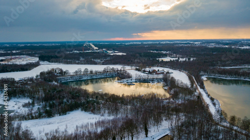 Aerial view of the winter snow covered forest and frozen lake from above captured with a drone. High quality photo © Bjorn B