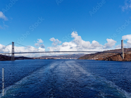 The Full span of the Askoy Suspension Bridge seen from a Vessel departing Bergen Port with its wake centred under the middle of the Bridge. photo