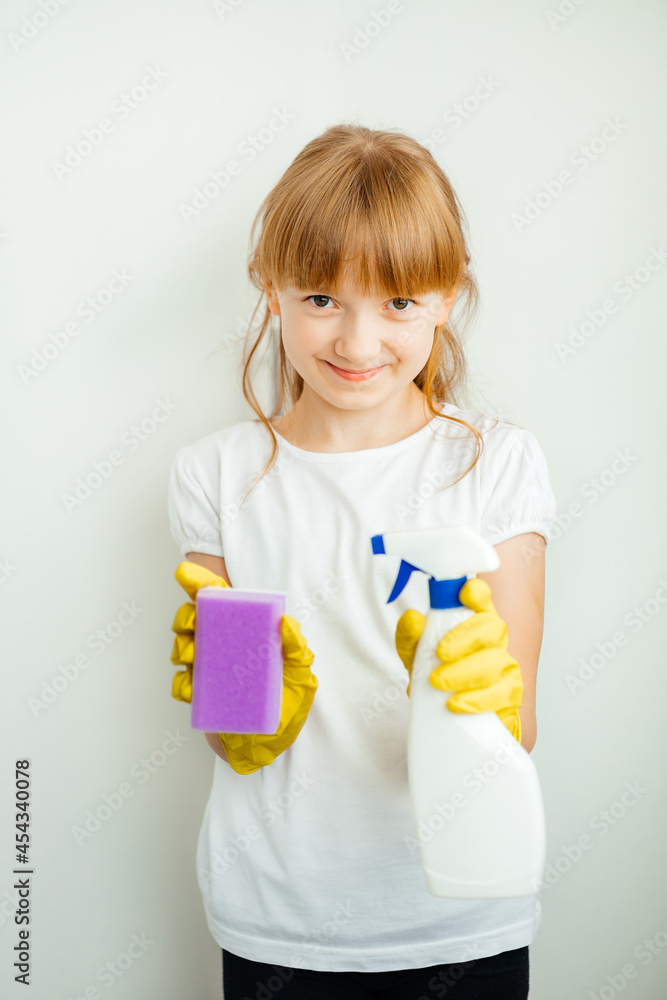 girl in yellow gloves with a white spray and a cleaning sponge girl in yellow gloves with a white spray and a cleaning sponge