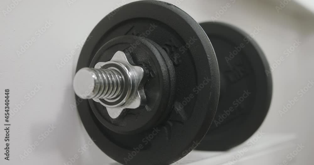 Male athlete putting down dumbbells to rack. Home fitness, training, workout, bodycare and wellness concept. closeup view Male athlete putting down dumbbells to rack. Home fitness, training, workout, bodycare and wellness concept. closeup view