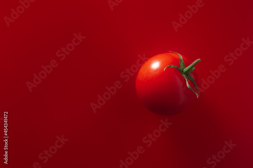 red juicy farm tomato on a red background