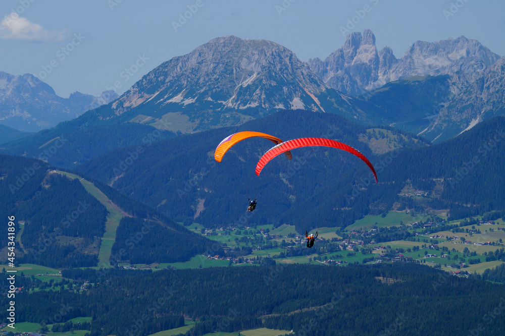 two friends paragliding in the Alps of the Dachstein region in Austria