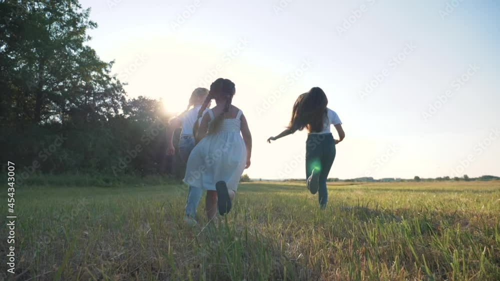 happy children runs along green meadow.Children run on grass at sunset. Summer outdoor activities. Healthy happy lifestyle of family, children. Summer vacation of freedom. Free children run at sunset. happy children runs along green meadow.Children run on grass at sunset. Summer outdoor activities. Healthy happy lifestyle of family, children. Summer vacation of freedom. Free children run at sunset.
