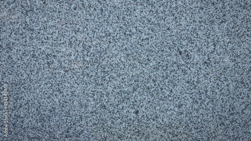 Gray blueish granite with black inclusions. Background granite texture, top view
