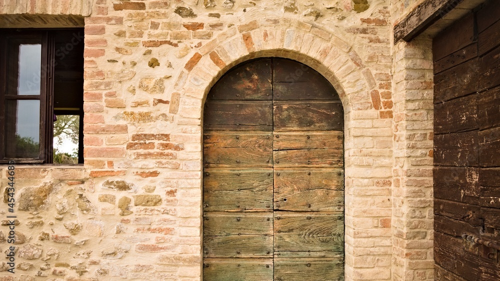 A rustic wooden green door in a stone cottage in the Italian countryside (Umbria, Italy, Europe)