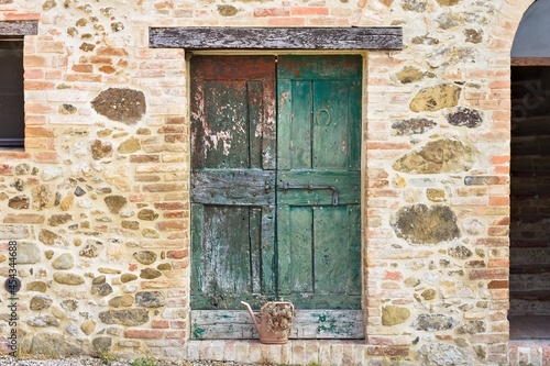 A rustic wooden green door in a stone cottage in the Italian countryside (Umbria, Italy, Europe)