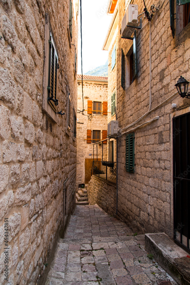 Narrow European street, ancient city, stone houses and paving stones.