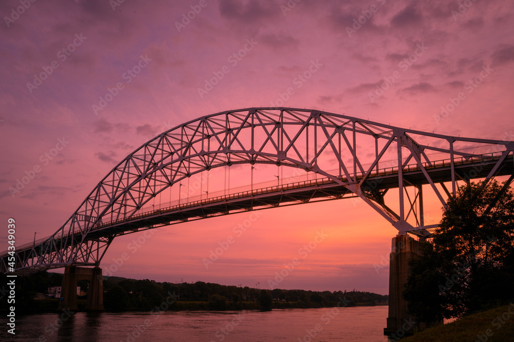 Sagamore Bridge over Cape Cod Canal at sunrise with high humidity in the summer