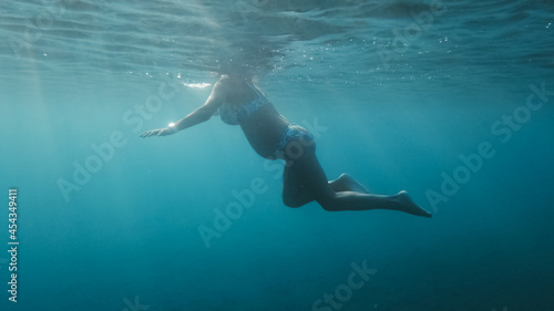 Giovane donna incinta fa ginnastica in gravidanza nell'acqua © Polonio Video