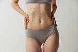 Beautiful body of young caucasian woman isolated on gray studio background. Natural beauty concept