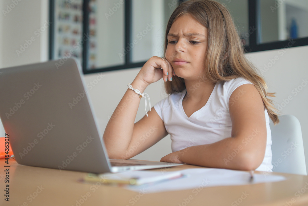 young girl on a laptop computer doing her lessons at home young girl on a laptop computer doing her lessons at home