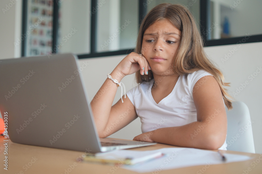 young girl on a laptop computer doing her lessons at home young girl on a laptop computer doing her lessons at home