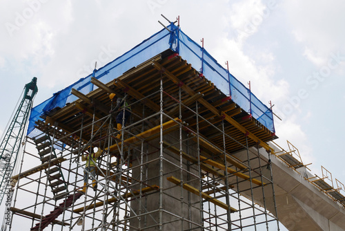 PENANG, MALAYSIA -JULY 2, 2021: The mega infrastructure structure is under construction. Construction workers are carrying out work with strict safety regulations. Temporary staging is installed. 