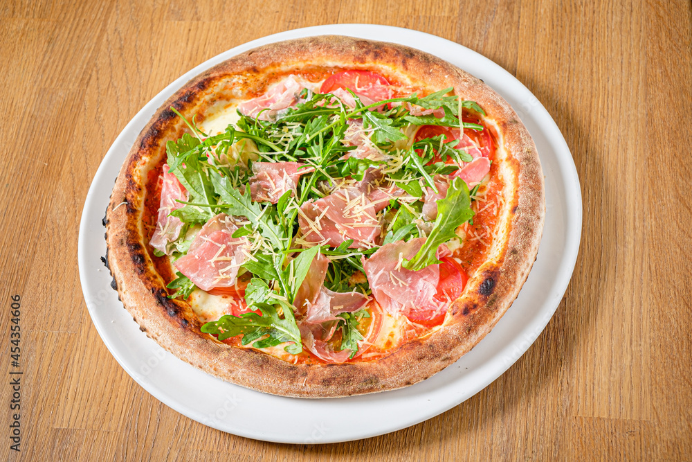 pizza with ham and rocket salad