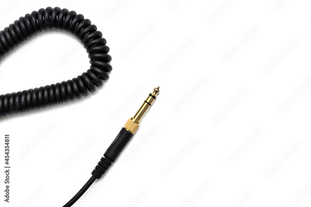 Stereo audio headphone jack with cable on white background. Gold jack plug for connecting audio devices and musical instruments. Electrical connector for analog audio signals. Stereo audio headphone jack with cable on white background. Gold jack plug for connecting audio devices and musical instruments. Electrical connector for analog audio signals.