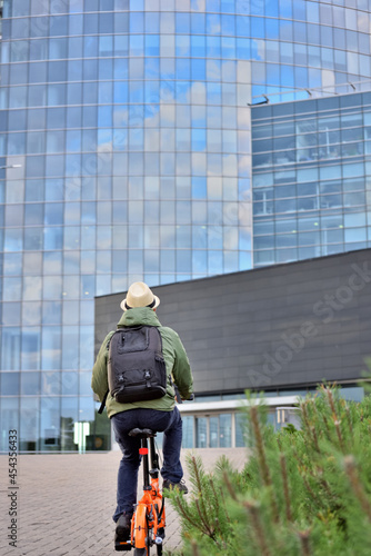 Man rides a bicycle to work. Office worker chooses an environmentally friendly mode of transport and rides a bicycle to work.