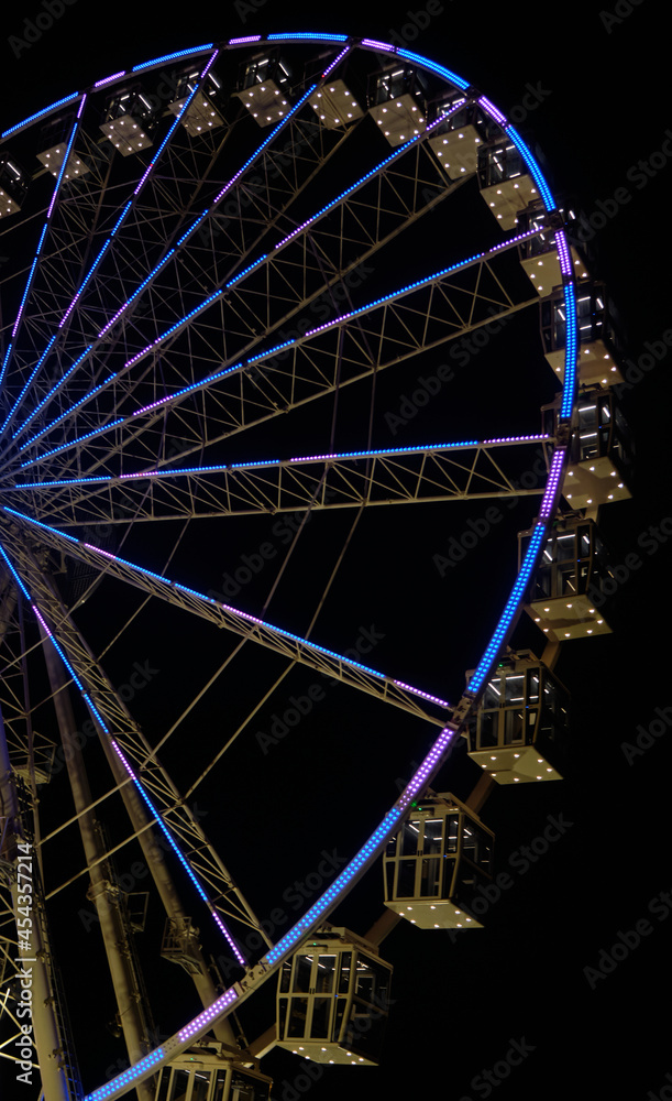 ferris wheel at night with lights in the city of Cagliari - Sardinia - travel destination.