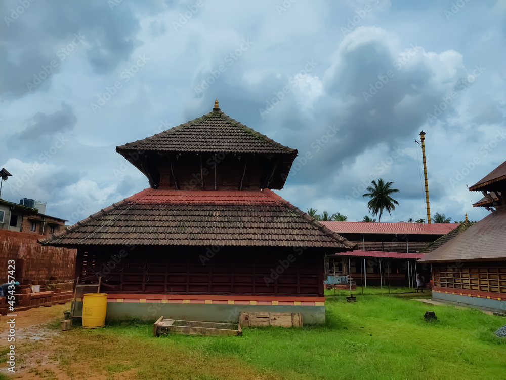 Addor Temple ancient Kerala architecture view under the sky. Beautiful design temple carvings surrounded by green grasses Addor Temple ancient Kerala architecture view under the sky. Beautiful design temple carvings surrounded by green grasses