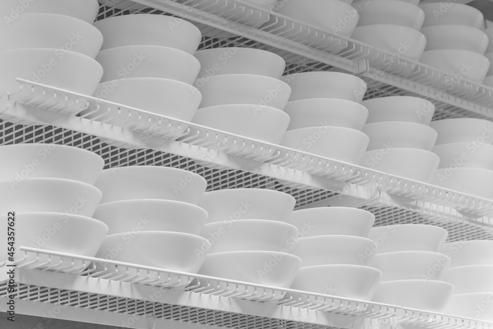 White plates on the showcase close up. White plates in arow White plates on the showcase close up. White plates in arow