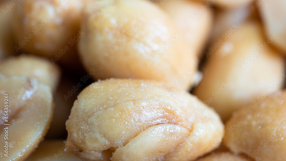 Amazing close up of salted peanuts in a pile. The peanuts are sweating heavily from the high concentration of salt. Allergies and snacks concept. Amazing close up of salted peanuts in a pile. The peanuts are sweating heavily from the high concentration of salt. Allergies and snacks concept.