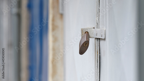 Photography Rusty padlock on a weathered white metal garage door in Bratislava