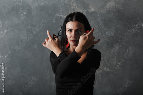 Young adult spanish woman dancing flamenco on grey vintage studio background