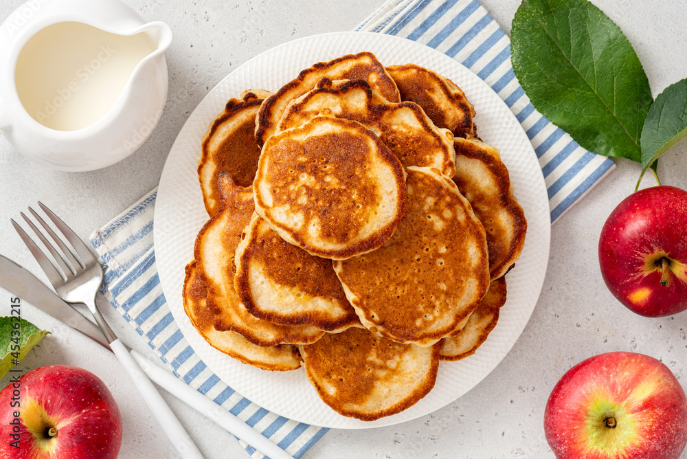 Homemade apple pancakes in a white plate on a gray concrete background top view. Tasty breakfast Homemade apple pancakes in a white plate on a gray concrete background top view. Tasty breakfast