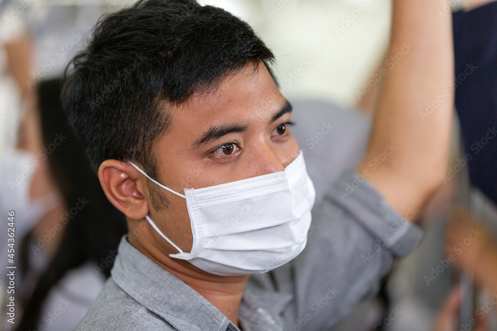 Asian businessman wearing face protective mask for protection from virus disease while standing on subway train, public transport during coronavirus, COVID 19 outbreak. health, safety Asian businessman wearing face protective mask for protection from virus disease while standing on subway train, public transport during coronavirus, COVID 19 outbreak. health, safety