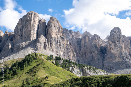 Alta Badia (Dolomiti) - August: Beautiful summer mountain view of Passo Sella and high peak Sassopiatto and Sassolungo, Langkofel, Dolomiti, Sella group. Green meadows and pastures, alpine dolomites