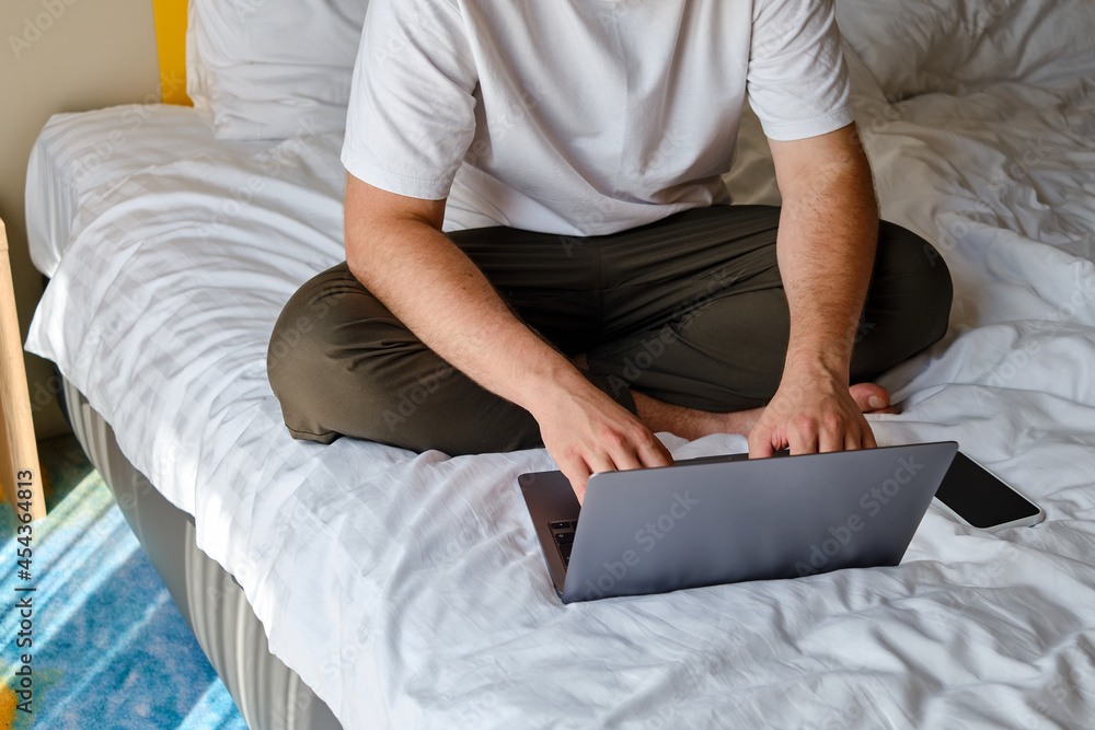 A man businessman sees negotiations through programs, applications on a laptop in bed. Working on a laptop. Business concept. Freelancer at work at home. Online communication A man businessman sees negotiations through programs, applications on a laptop in bed. Working on a laptop. Business concept. Freelancer at work at home. Online communication
