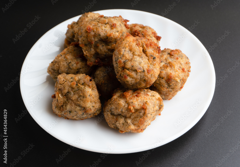 Chicken kofta meatballs mixed with ingredients of onions, garlic fresh herbs and spices mixture on black background Chicken kofta meatballs mixed with ingredients of onions, garlic fresh herbs and spices mixture on black background