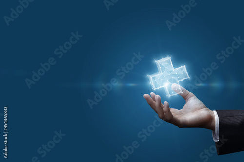Businessman hand shows hologram of plus sign .