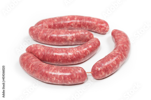 Five crude sausages on a white background