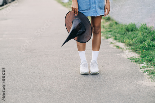 Halloween costume concept. Lifestyle young woman holding a black witch hat.