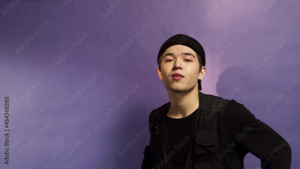 Portrait of a teenage guy in black hat on a purple background Portrait of a teenage guy in black hat on a purple background