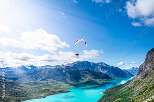 A paragliderpilot is flying over Besseggen in Jotunheimen. A famous national park in Norway