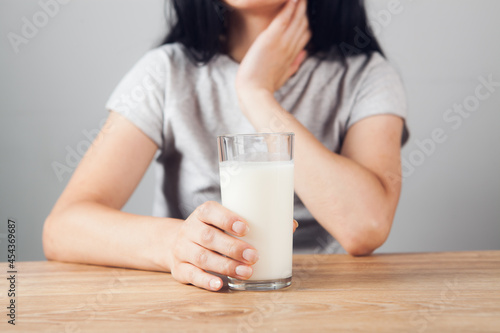 girl at the table holds a glass of milk