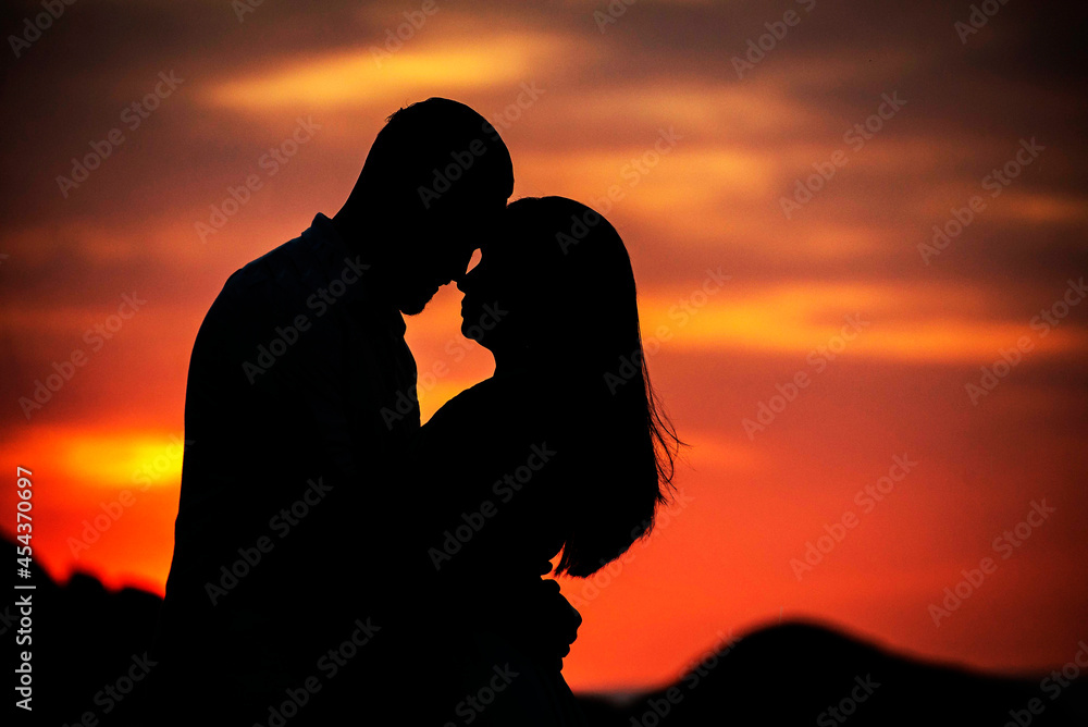 casal se beijando com entardecer vermelho