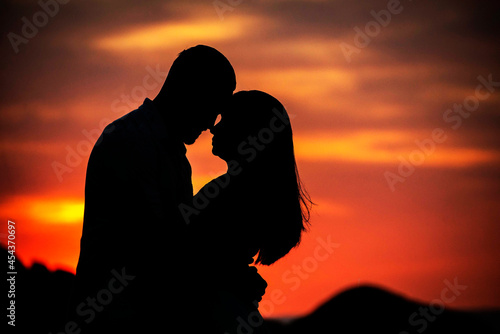 casal se beijando com entardecer vermelho photo