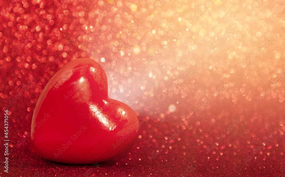 Fototapeta premium Red heart on a red shiny background with light