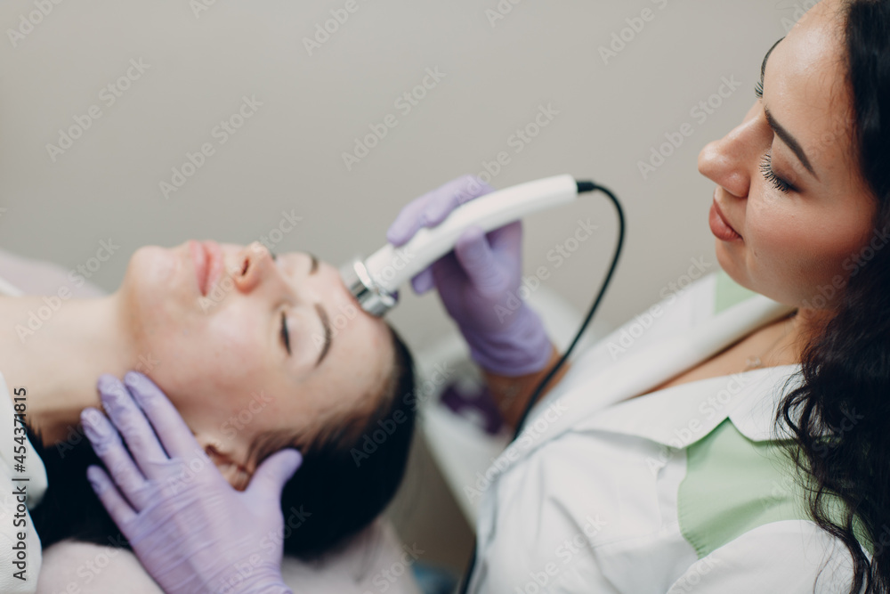 Naklejka premium Close up of head woman receiving electroporation phonophoresis facial therapy at beauty spa salon