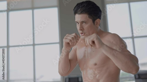 Athlete muscular topless man fist punch and uppercut training at the fitness. combat fighting exercise. boxing sport for health and self protection. 4K slow motion